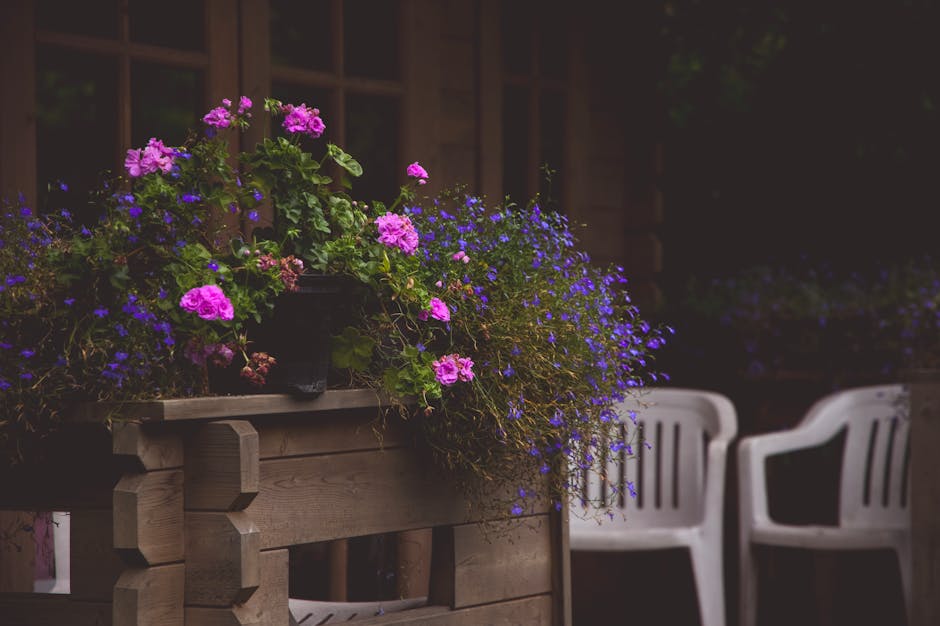 A cozy outdoor patio in Warsaw with vibrant flowers and seating, perfect for summer relaxation.